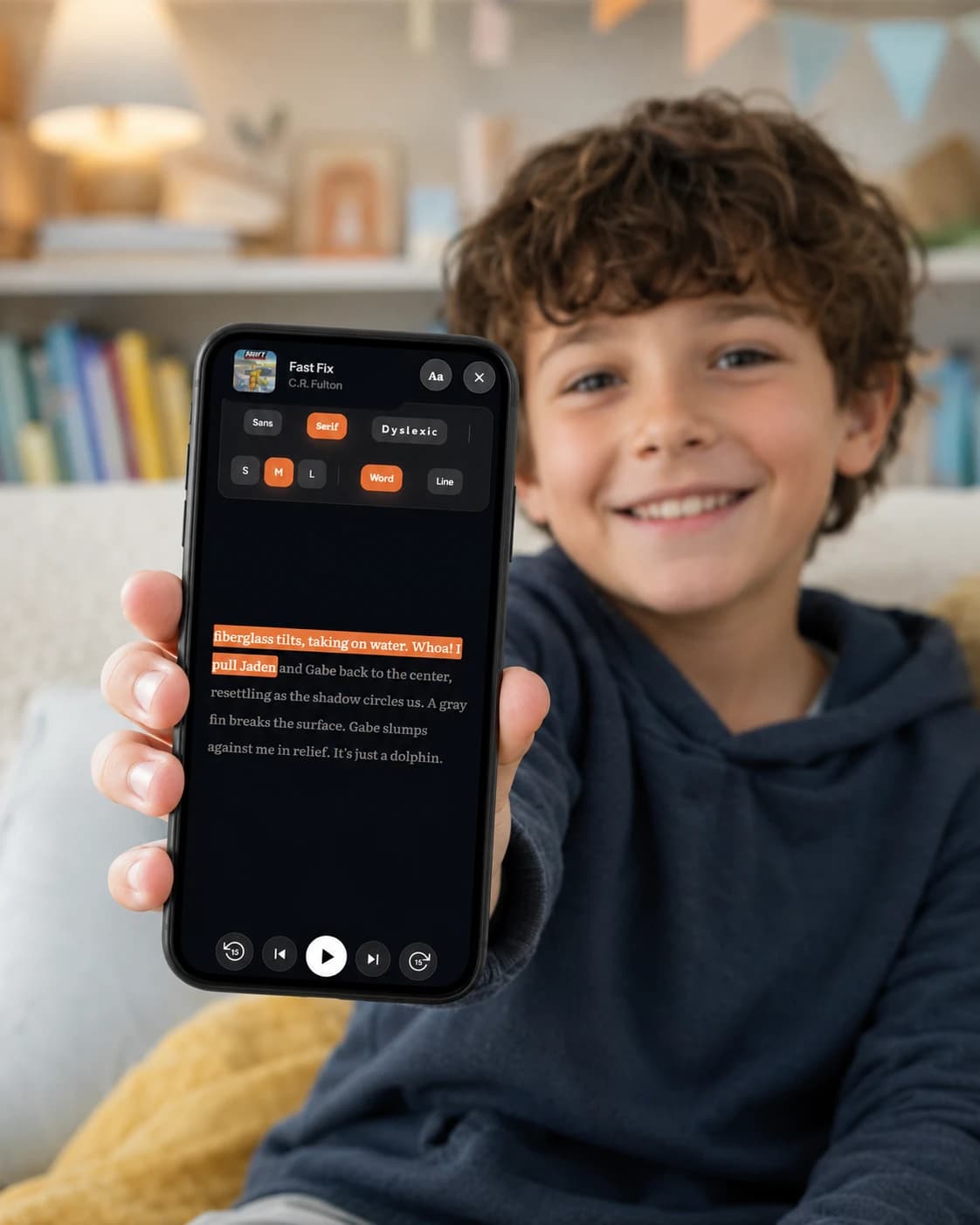A smiling boy holding up a phone with Sherwood's audiobook captions on screen in dark mode, one line highlighted in orange as the narrator reads it — bookshelf in the background